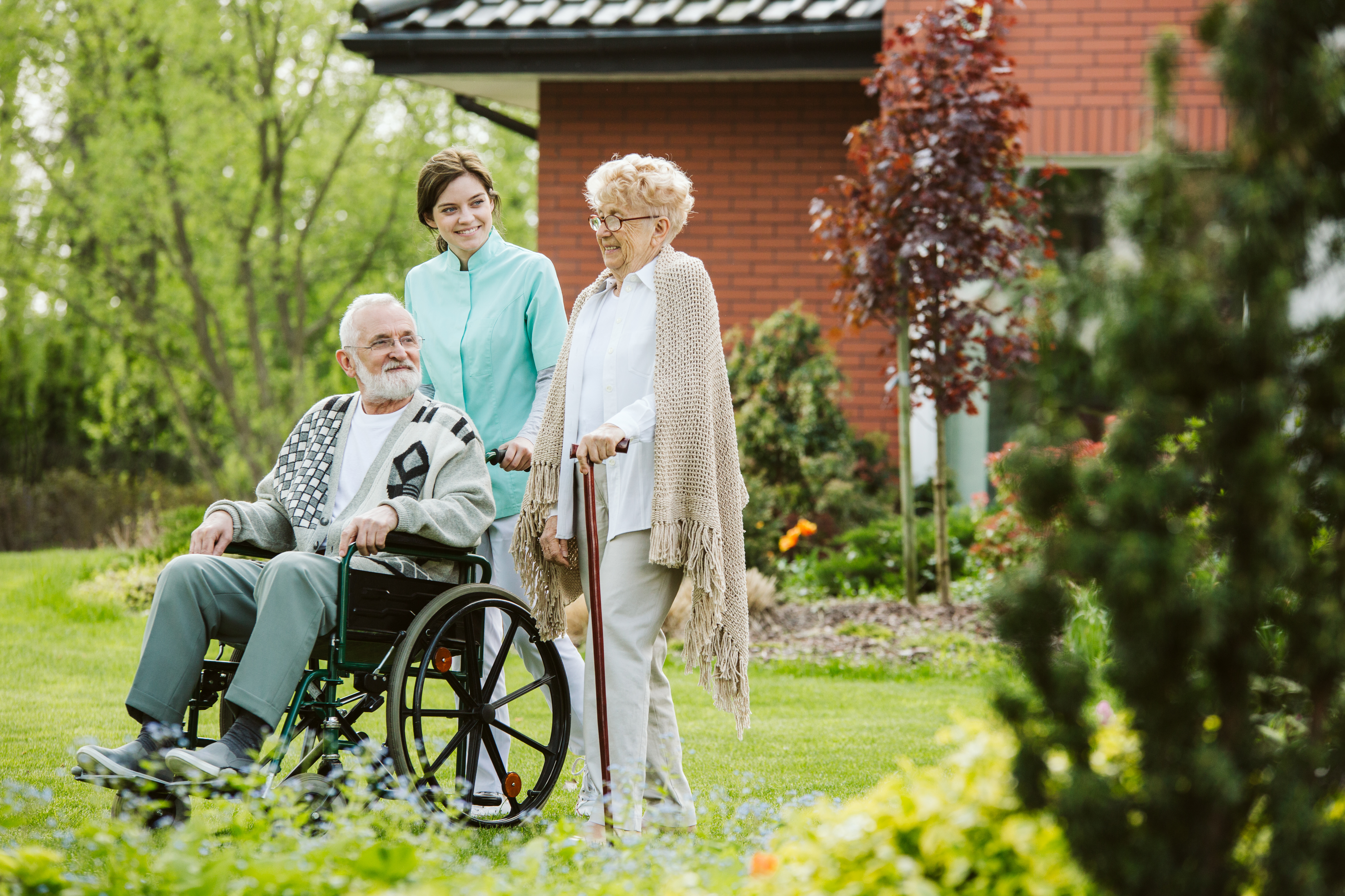 senior man on the wheelchair in the garden of professional nursing home